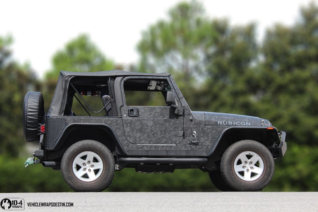 Side view of a Jeep Rubicon with custom camo wrap and bold vinyl lettersJeep Rubicon Camo Wrap Side Profile with Custom Lettering